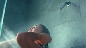 Woman showering with water-saving shower head